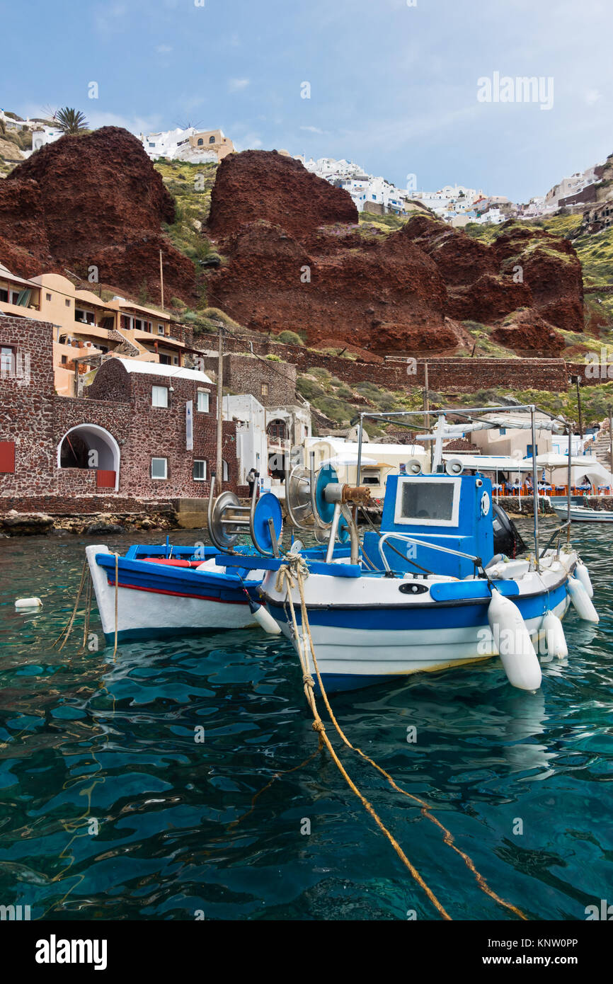 Barcos de pesca en la aldea de Oia, debajo de puerto Caldera acantilado en Santorini Island Foto de stock