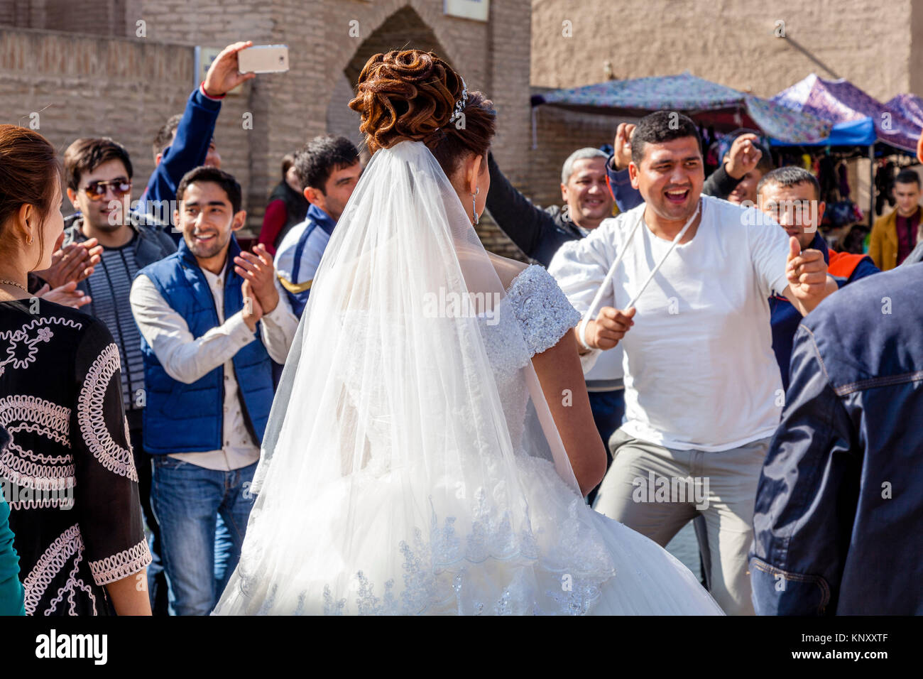 Los invitados a la boda Bailar en la calle durante una celebración de boda, Khiva, Uzbekistán Foto de stock