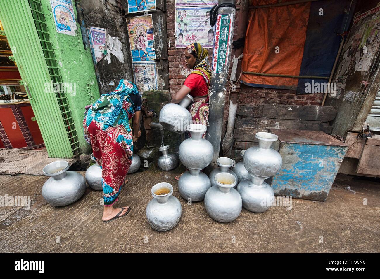 Las mujeres llenar jarras de agua en Dhaka, Bangladesh. Foto de stock