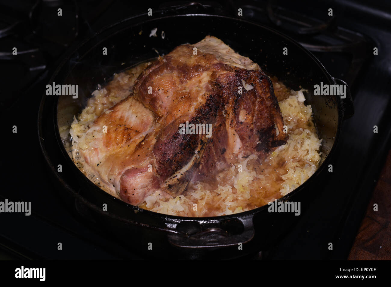 Costilla de cerdo asado final cocinar con chucrut en un antiguo horno holandés Griswold de hierro fundido en un frío día de invierno especulador, NY Foto de stock