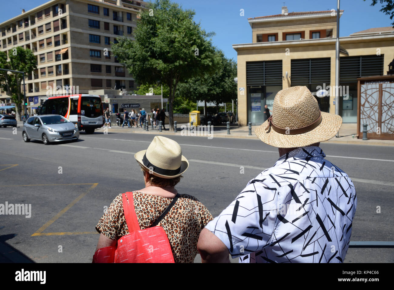 Pareja Middle-Aged en sombreros de Paja esperando Bus en Aix-en-provence Provence Francia Foto de stock