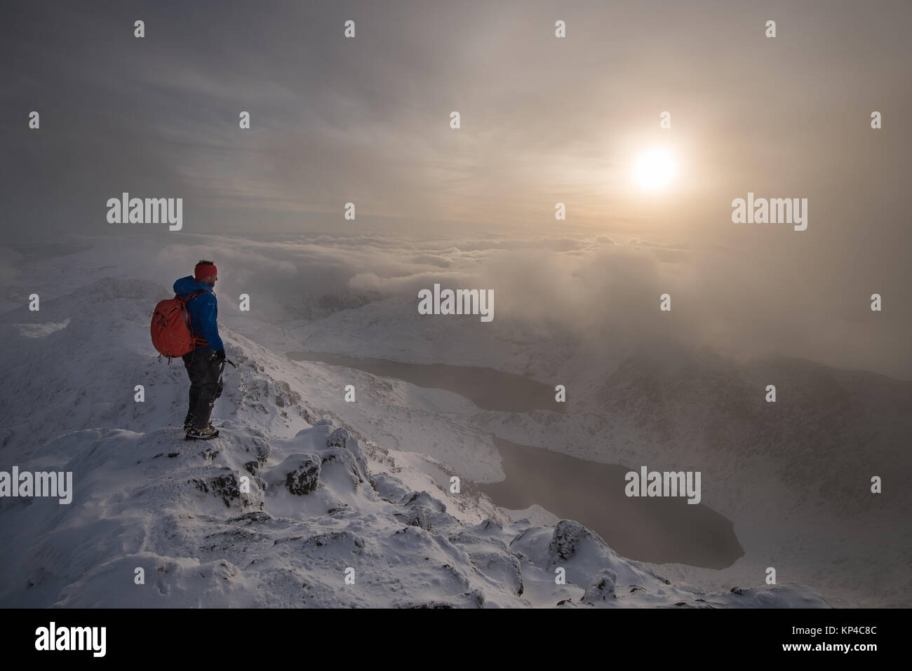 Figura en montañas nevadas cape en Snowdonia, montañismo mochila, antorchas, Foto de stock