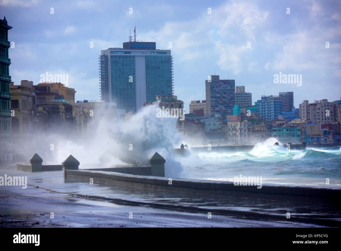 Las salpicaduras de las olas hacia el muro de contención contra el cielo nublado, La Habana, Cuba. Foto de stock