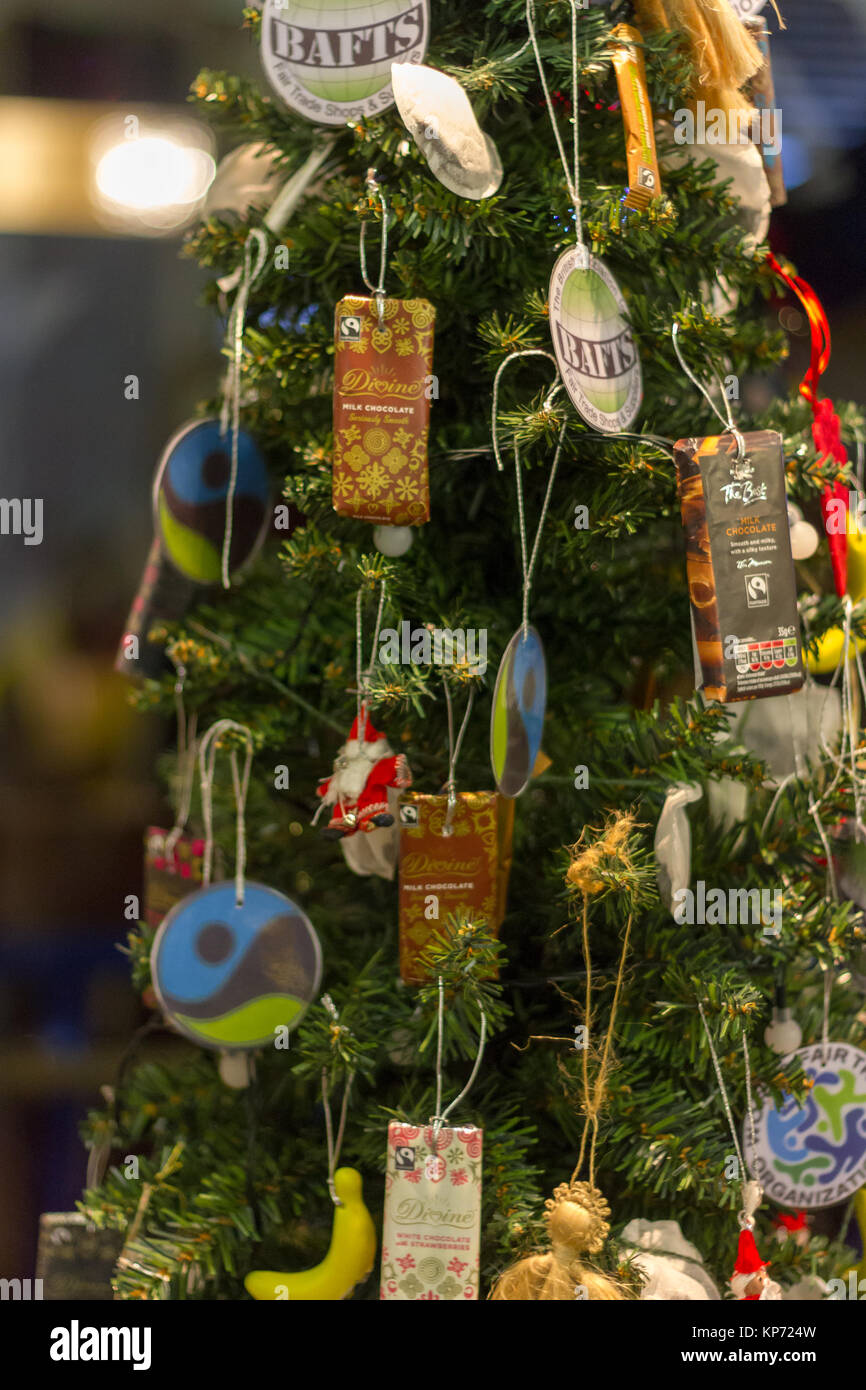 Decoraciones temáticas Fair-Trade sobre un árbol de Navidad. En exhibición en la Iglesia Metodista, Totnes Totnes, Devon, Reino Unido Foto de stock