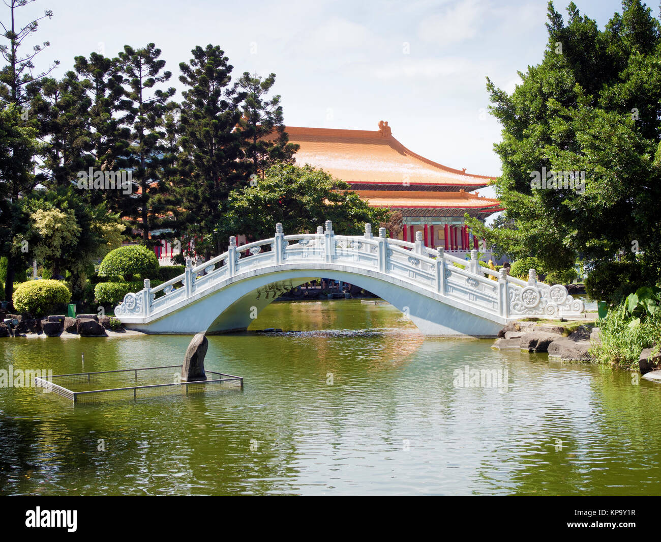 Puente de piedra blanca en un jardín de Asia Foto de stock