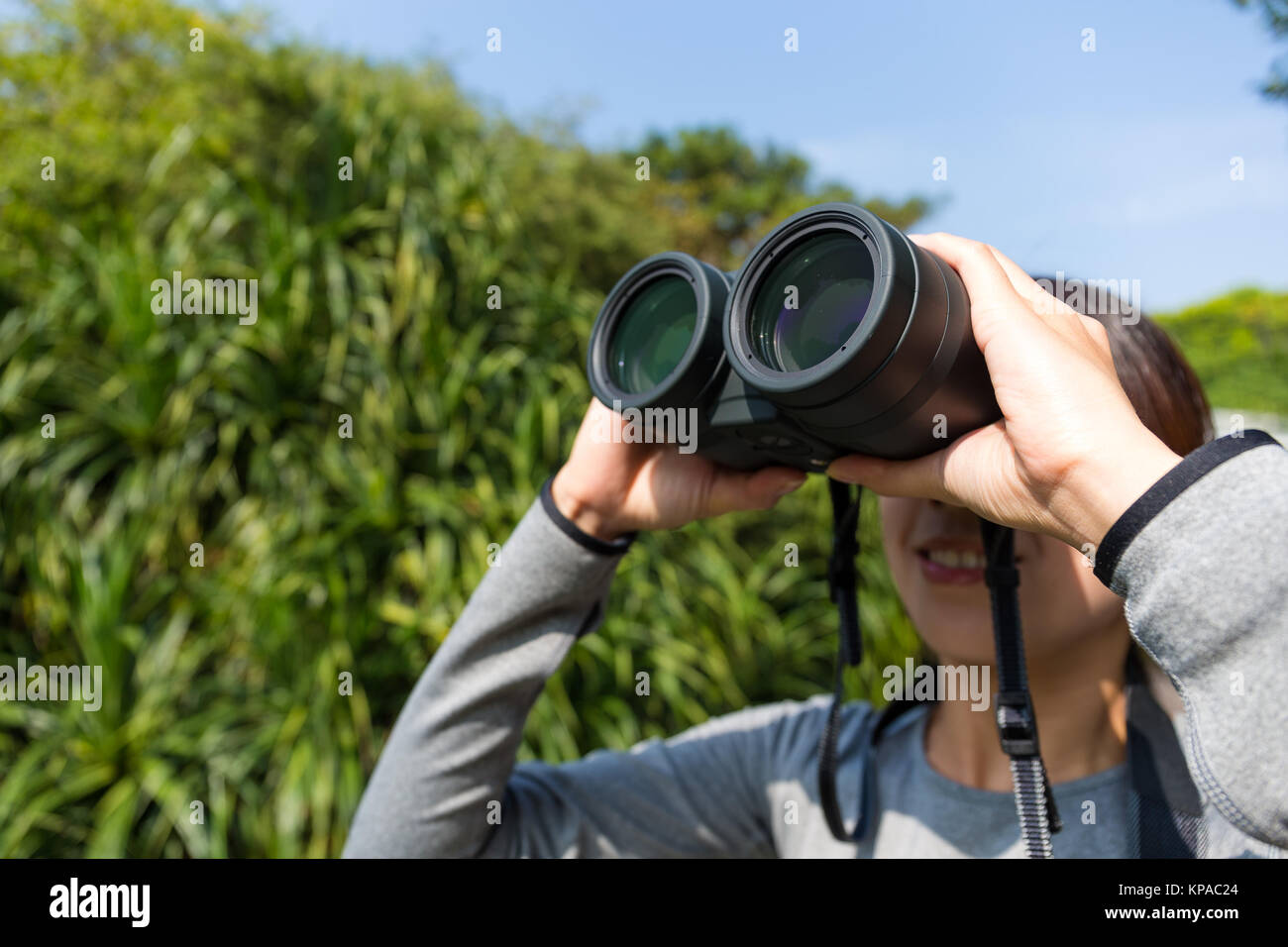 Mujer joven utilización de los prismáticos para observación de aves Fotografía de stock - Alamy