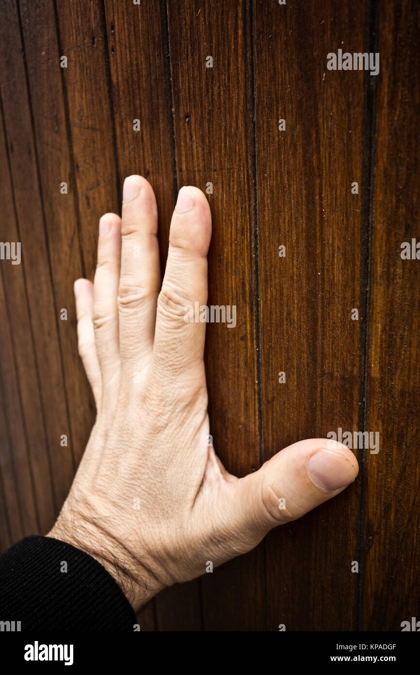 Hombre mano tocando una superficie de madera, un concepto para el sentido del tacto Foto de stock