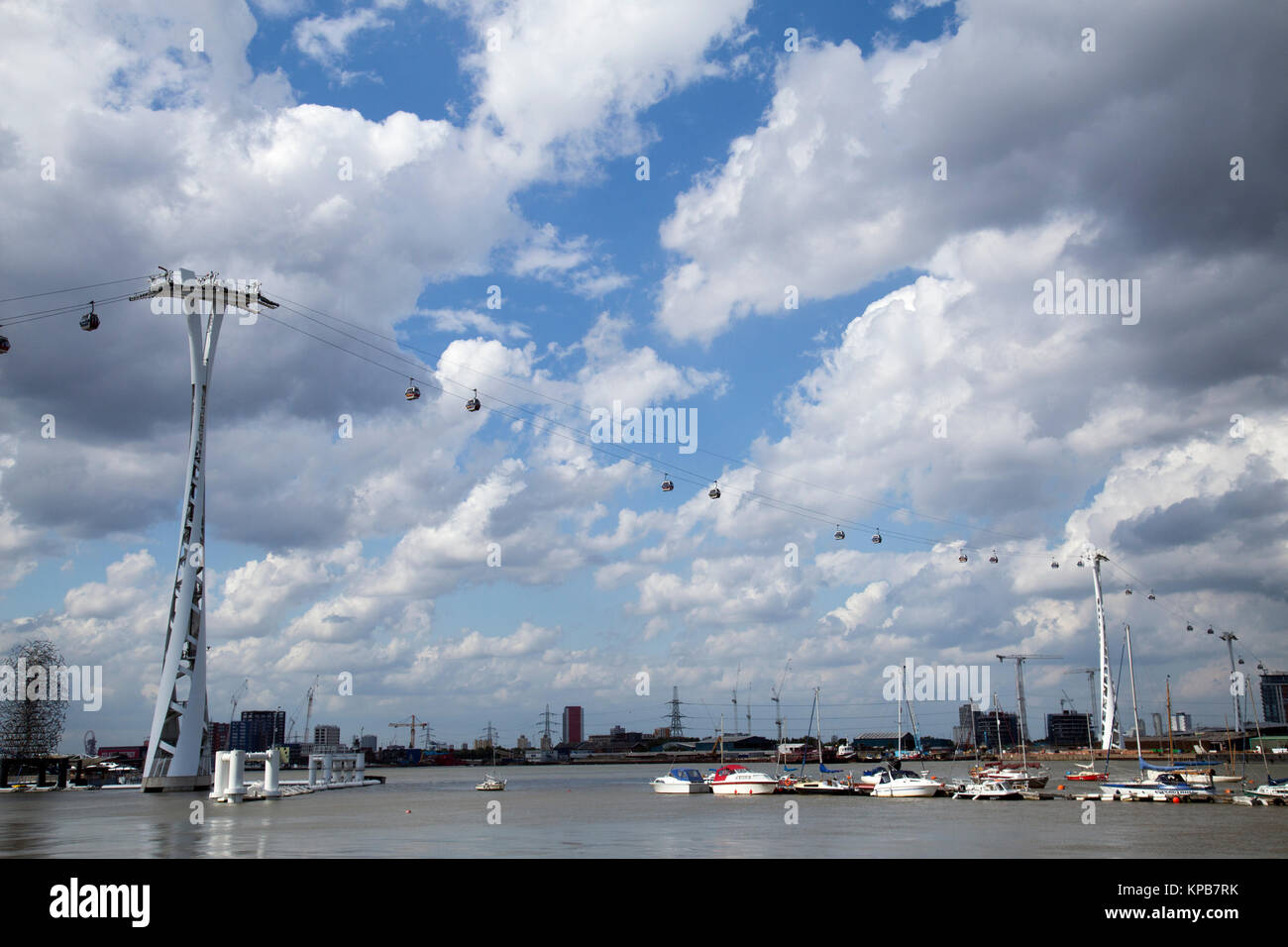 Londres teleférico que atraviesa el río Támesis con fondo de cielo nublado y barcos en primer plano, tomado de North Greenwich lado del río Foto de stock