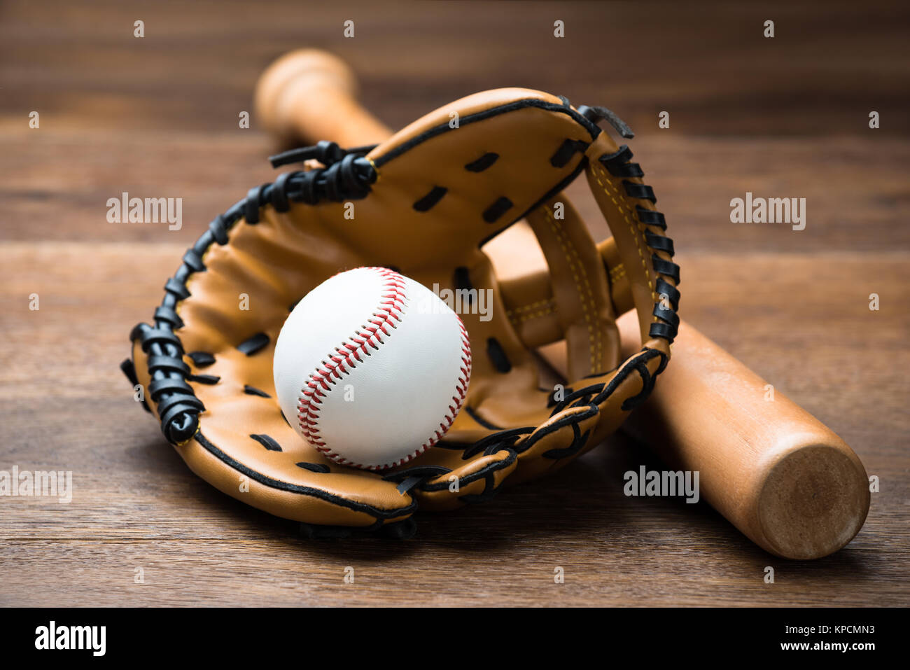 Un guante de béisbol y la bola con el bate en la tabla Fotografía de stock  - Alamy