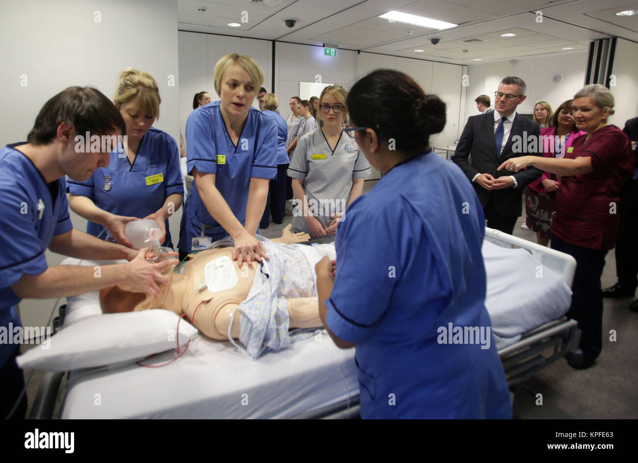 El Secretario de Hacienda de escocés Derek Mackay (segundo a la derecha) observa una sesión de enseñanza sobre reanimación cardio-pulmonar (CPR) en un entorno simulado de Ward, en el centro de enseñanza y aprendizaje, el Queen Elizabeth Hospital Universitario, Glasgow. Foto de stock
