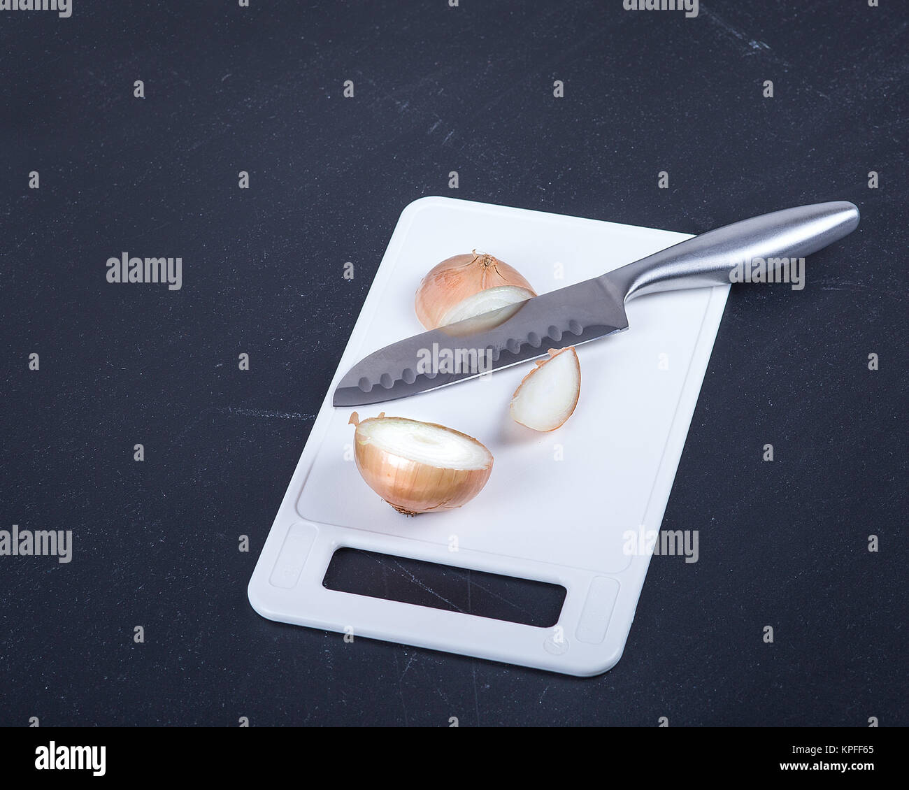 Acero inoxidable cuchillo del chef y cortar la cebolla sobre una tabla de  cortar Fotografía de stock - Alamy