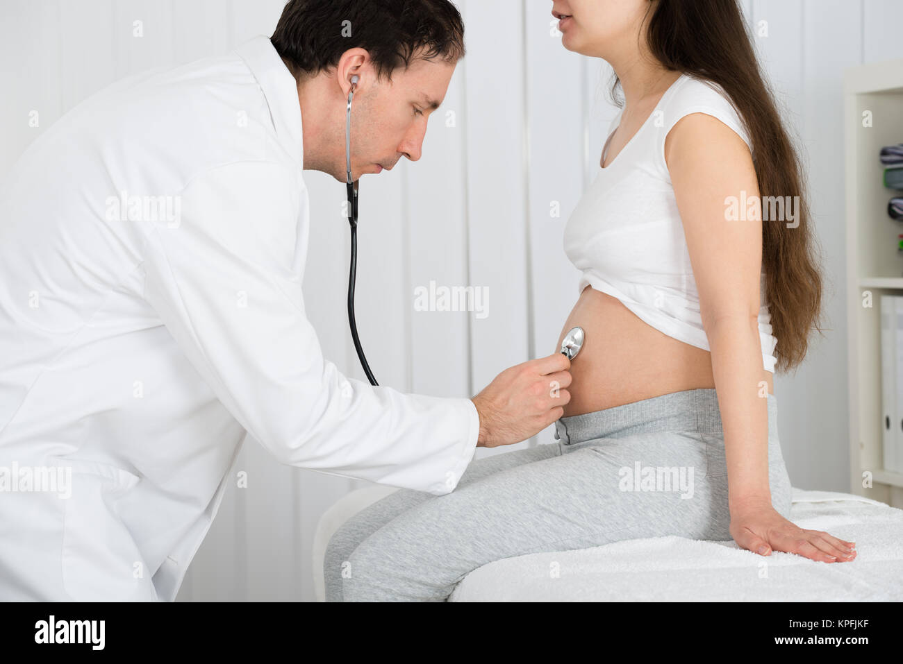 Médico examina la mujer embarazada en la clínica Foto de stock