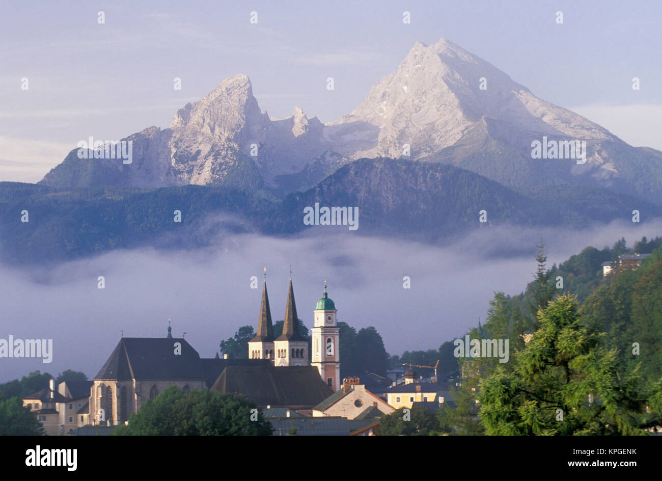 Alemania, Berchtesgaden. Campanarios de Saint Andrews y San Pedro en la niebla se disipa bajo Watzman montaña. Foto de stock