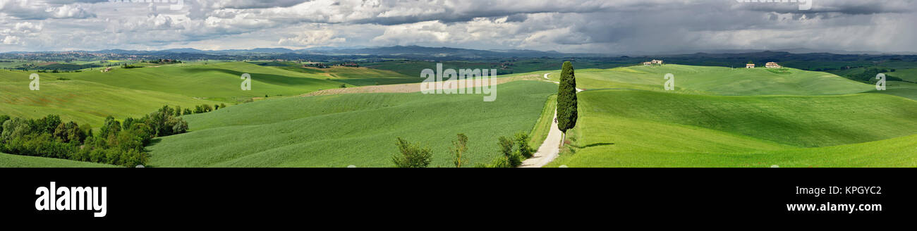 A través de la sinuosa carretera agrícola región de la Toscana, con nubes de tormenta, Italia. Foto de stock