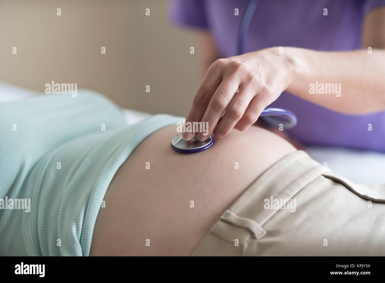 La comadrona escuchar latidos del corazón del bebé, la mujer embarazada  está acostado Fotografía de stock - Alamy