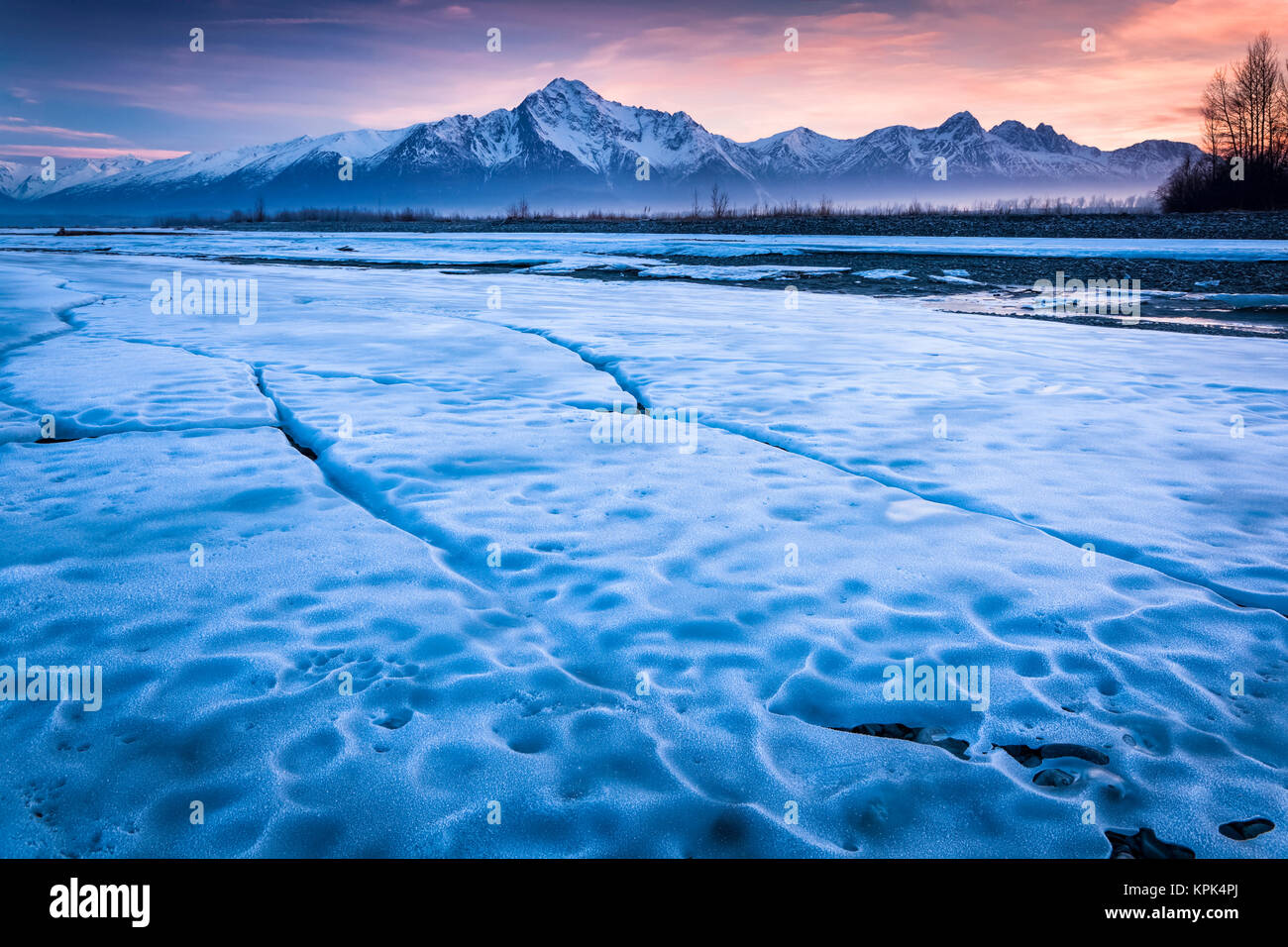 Hoja de hielo a lo largo de Matanuska Río con un atardecer cielo y montañas Chugach en el fondo; en Palmer, Alaska, Estados Unidos de América Foto de stock