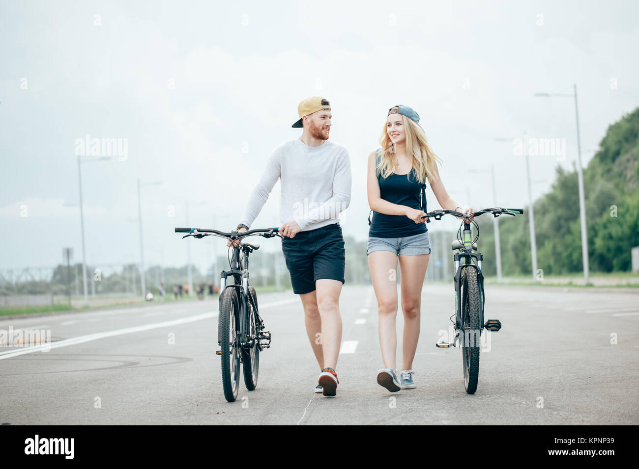 Pareja joven caminar juntos en el camino de bicicletas Fotografía de stock  - Alamy