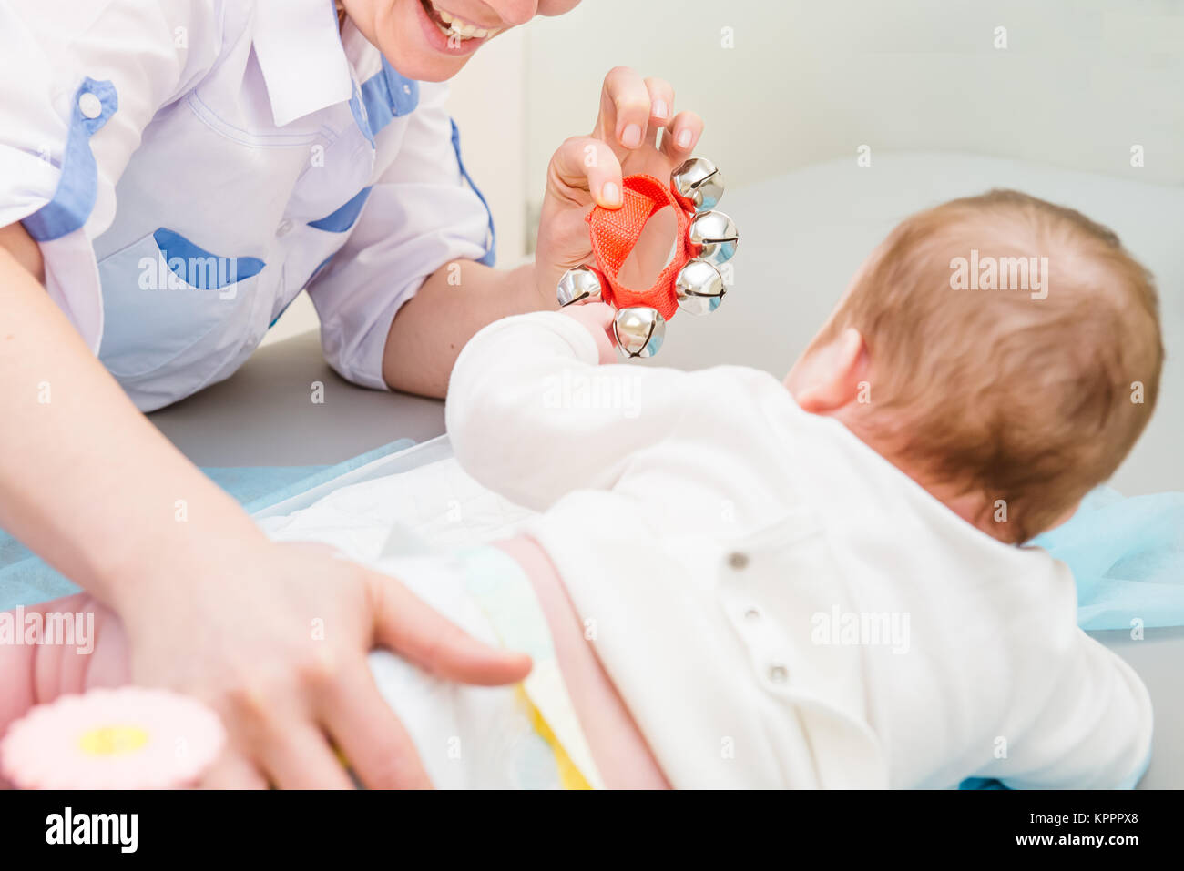 Cerrar el doctor con el recién nacido en la moderna clínica pediátrica. Motor infantil educación. El enfoque selectivo. Espacio para el texto Foto de stock