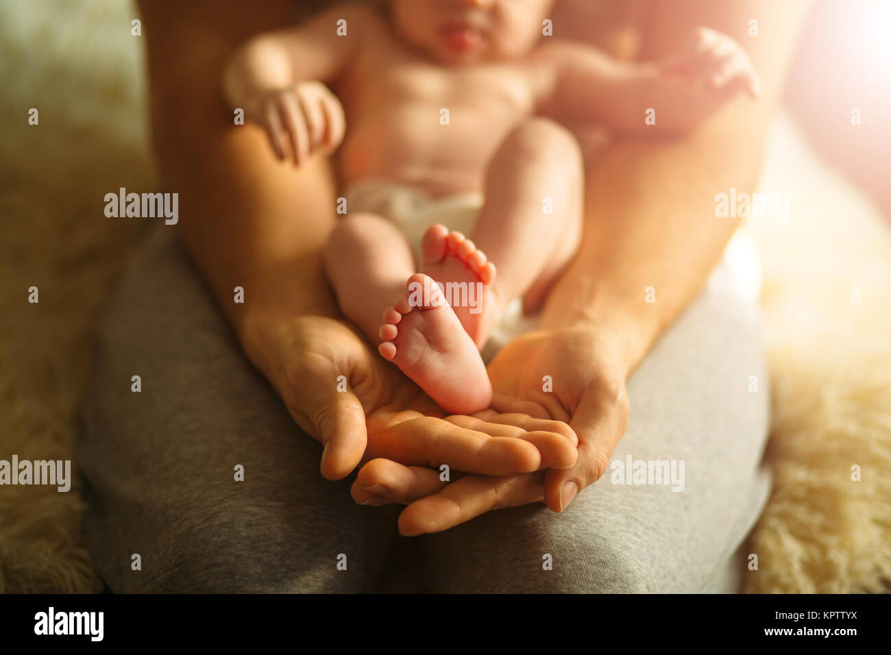 La madre del bebé recién nacido tiene feets. Pies diminutos en mano de mujer. Foto de stock