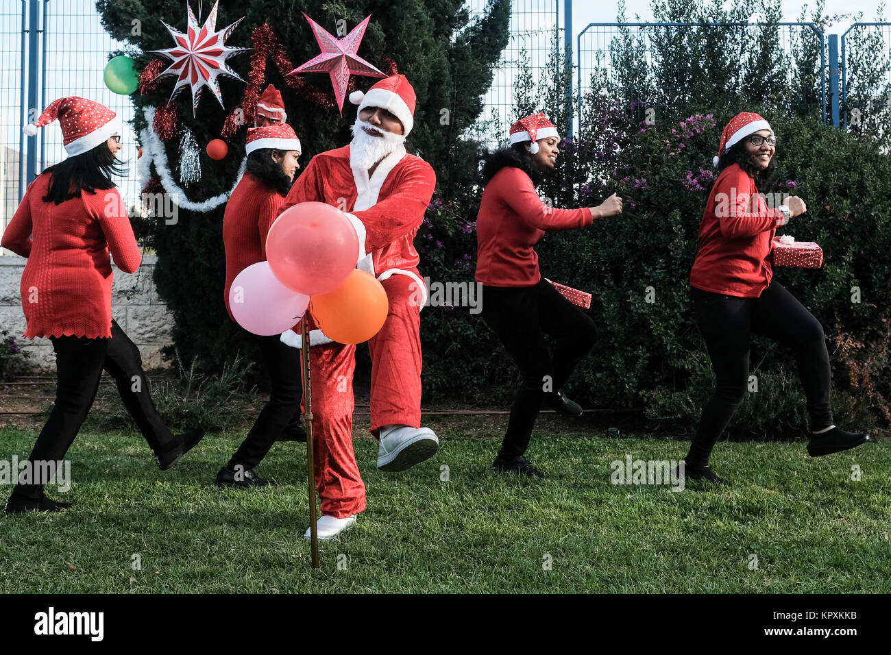 Jerusalén, Israel. 17 de diciembre de 2017. Los trabajadores extranjeros  procedentes de la India, vestidos con trajes de Santa Claus, preparar un  clip de vídeo para enviar a sus familiares en Navidad.