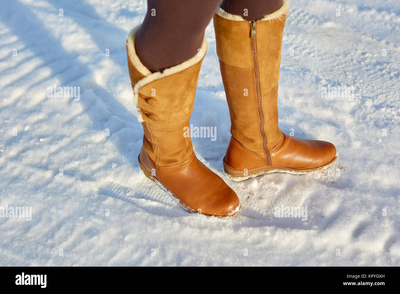 Pierna mujer invierno botas de piel marrón caminando sobre la nieve en  Winter Park. Closeup suela de arranque en caliente Fotografía de stock -  Alamy