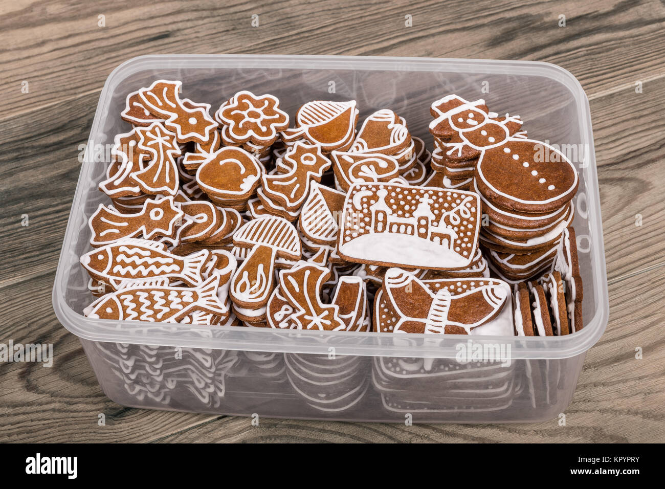 Hermosa Navidad gingerbreads artesanales tradicionales. Caja de plástico  transparente con montones de pasteles decorados a mano sobre un fondo de  madera Fotografía de stock - Alamy
