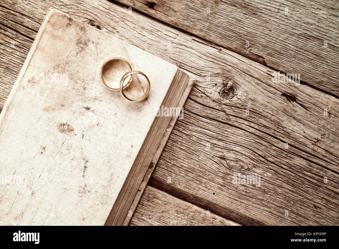 Los anillos de boda Sobre el viejo libro Foto de stock