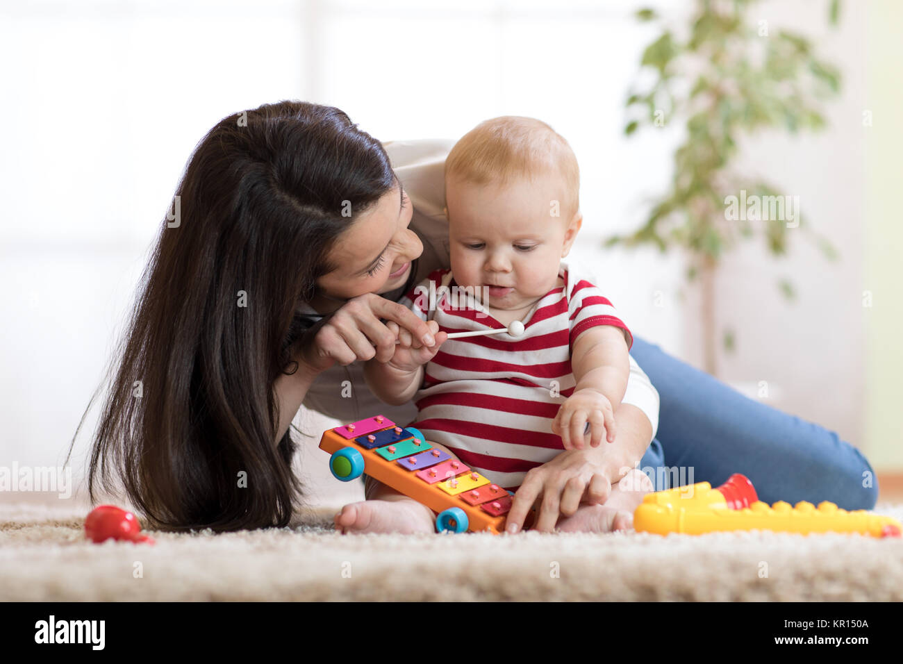 La madre y el niño lindo boy jugar juntos en interiores en casa Foto de stock