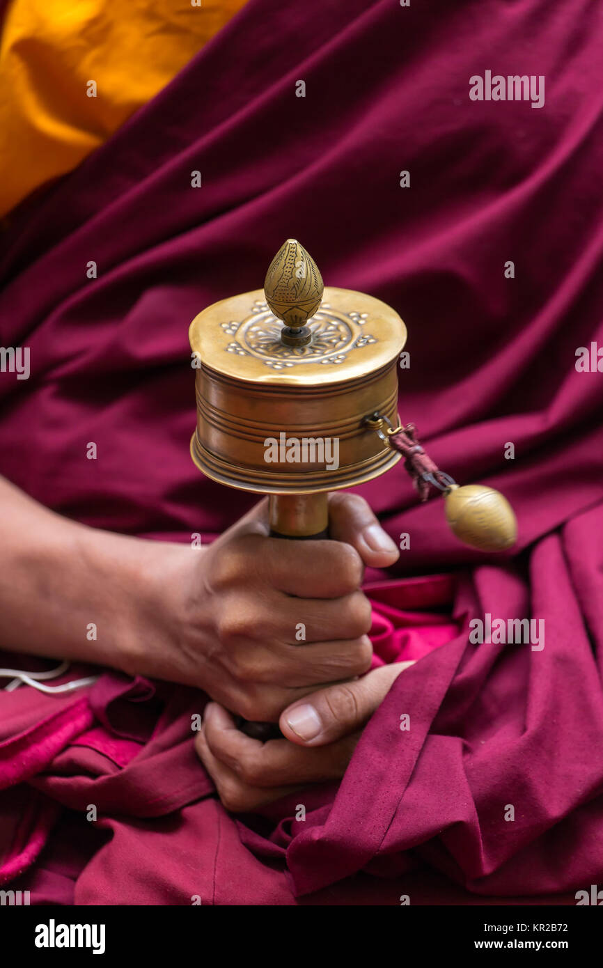 Rueda de oración de los monjes tibetanos en manos de cerca Foto de stock