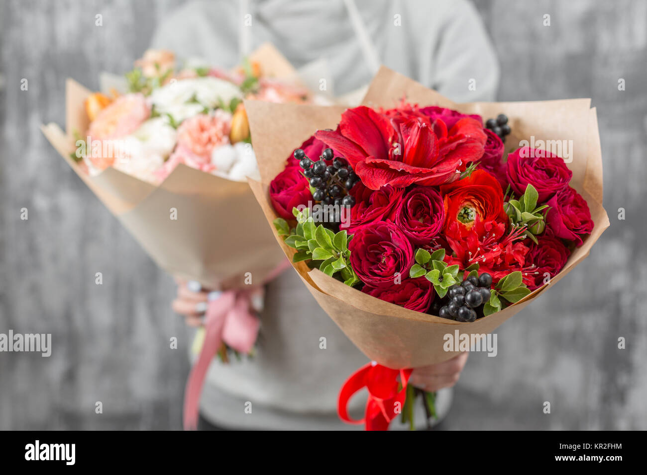 Dos hermosos lujo ramos de flores variadas en mujer mano. La labor de la  floristería en una tienda de flores. y delicado color rojo brillante  Fotografía de stock - Alamy