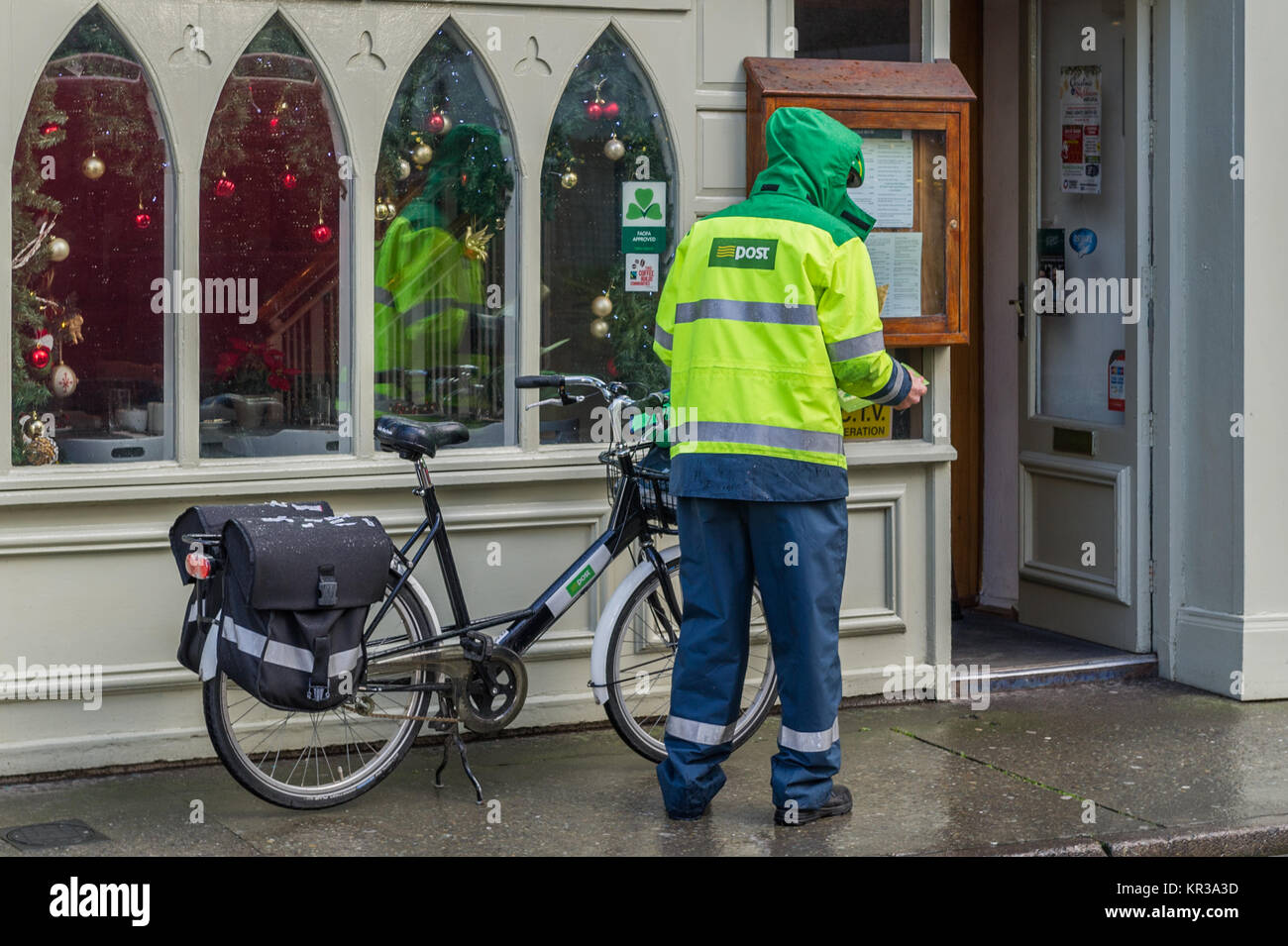 Cartero trabaja para un post entregar cartas en un push bike en Skibbereen, West Cork, Irlanda. Foto de stock
