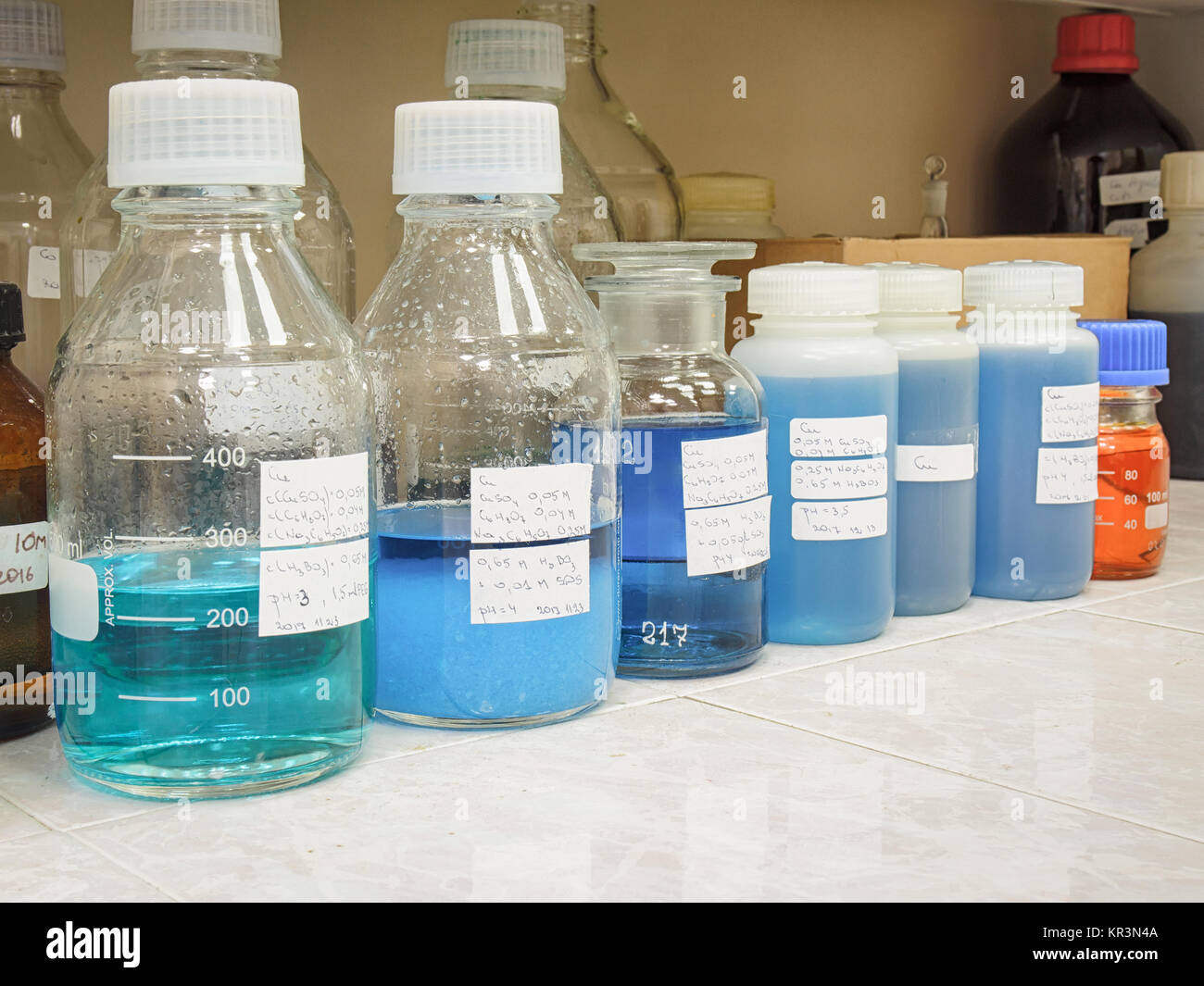 Solución azul en contenedores químicos en un laboratorio químico Foto de stock