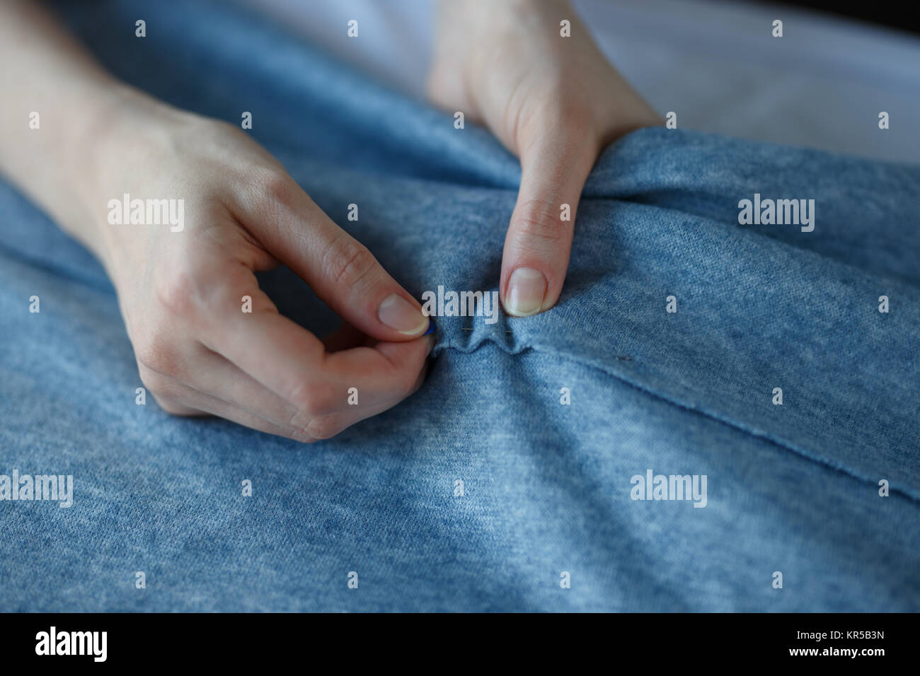 Acercamiento de sastre calificados manos marcado y medición de tela, mientras que la confección de ropa. Foto de stock