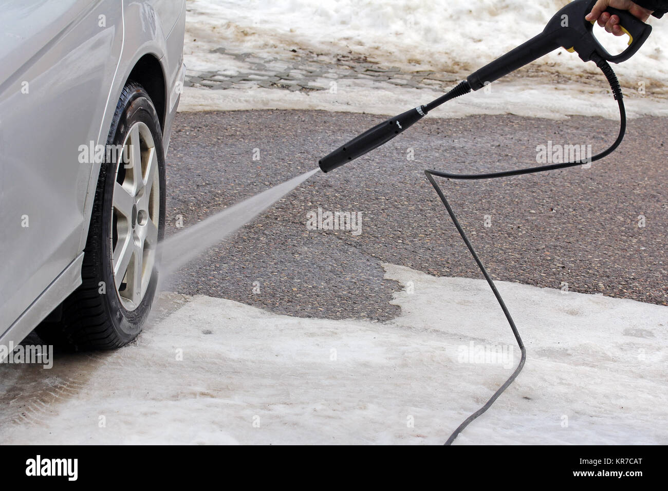 Lavado de coches en invierno - un hombre lava su coche Foto de stock