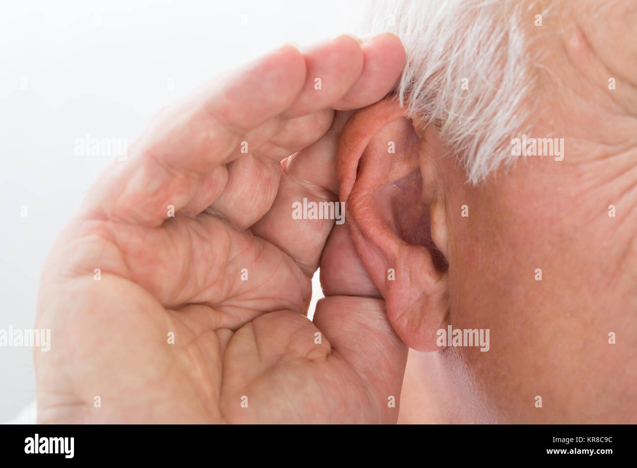 Close-up de un hombre intentando escuchar Foto de stock