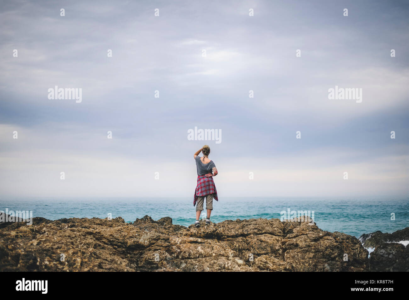 Australia, Nueva Gales del Sur, Mujer de pie sobre un acantilado y mirando a ver Foto de stock