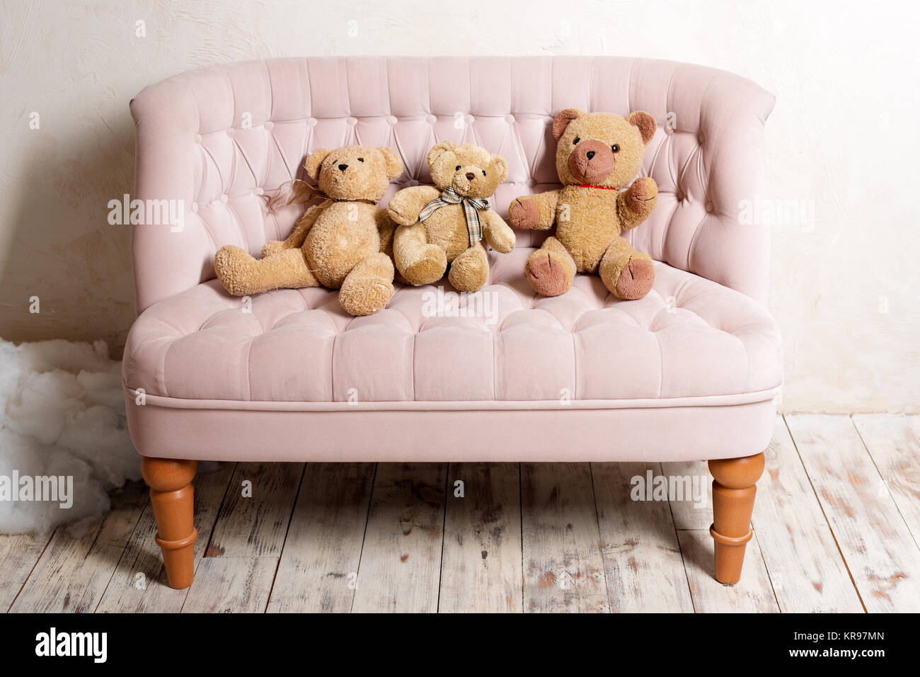 Tres osos de peluche sentado en un sofá rosa Fotografía de stock - Alamy