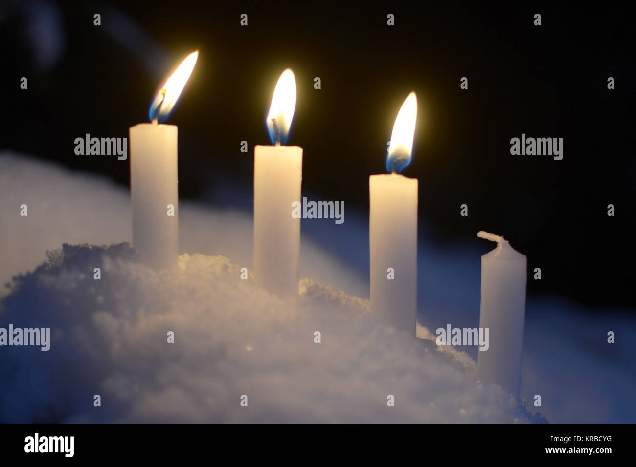 Tres velas encendidas de velas blancas al aire libre en la nieve Fotografía  de stock - Alamy