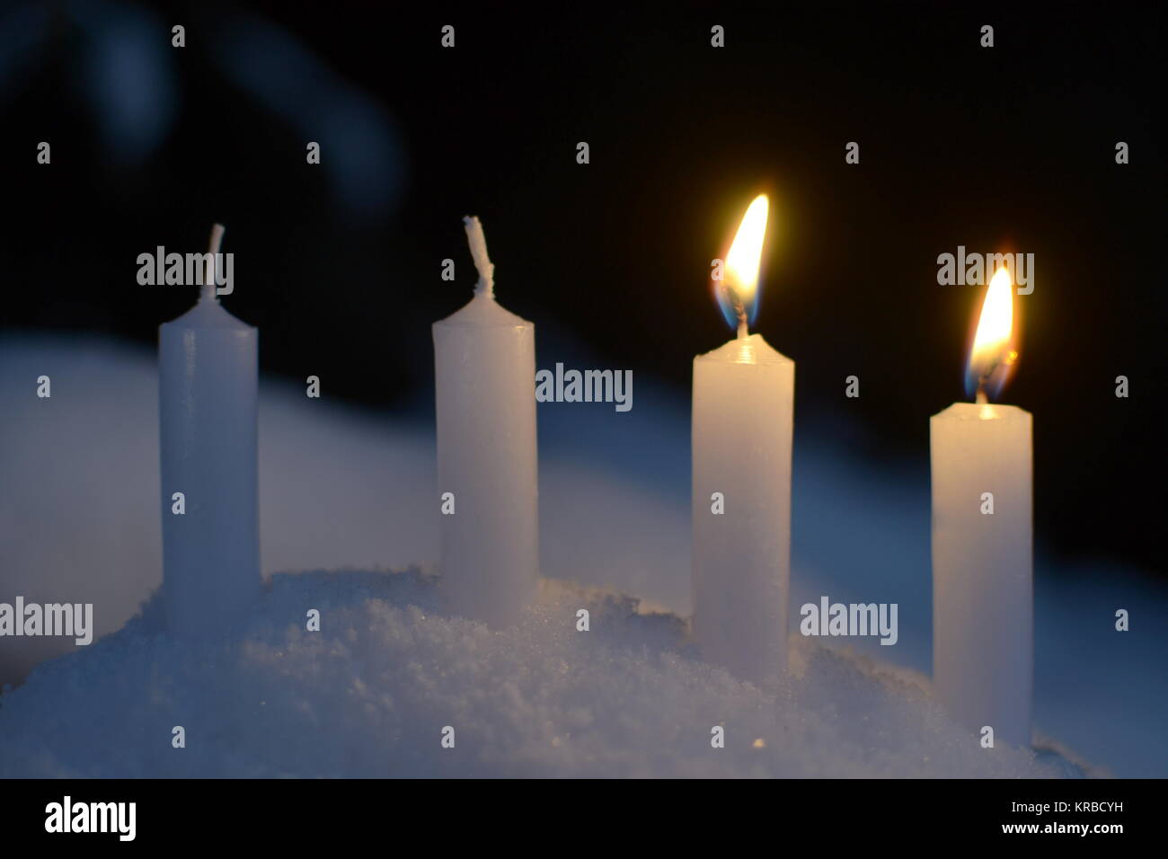 Dos velas encendidas de velas blancas al aire libre en la nieve Fotografía  de stock - Alamy