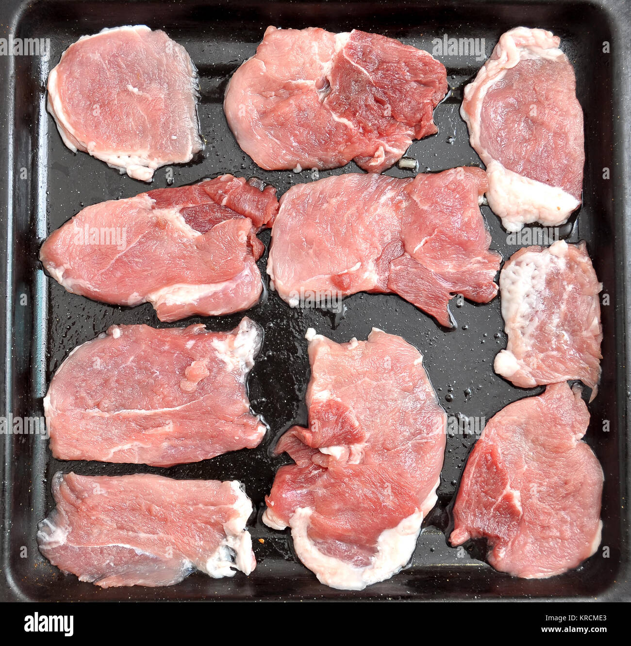 Chuletas de cerdo cruda sobre una bandeja para hornear. negro proceso de  cocción paso a paso. Vista superior, plano laical Fotografía de stock -  Alamy