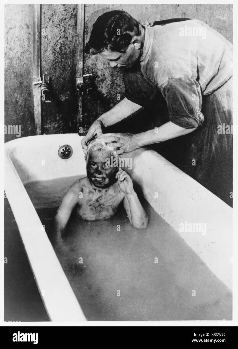 Un sucio Federación huérfano es dado un baño completo. Fecha: 1925 Foto de stock