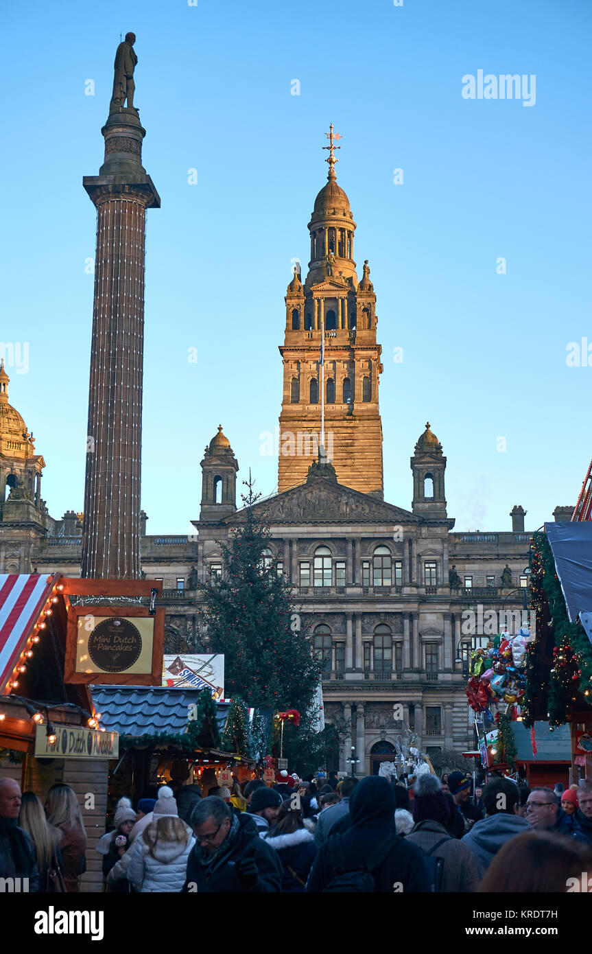 Mercado navideño en la plaza George en Glasgow, con la construcción de las salas de la ciudad en el fondo. Foto de stock