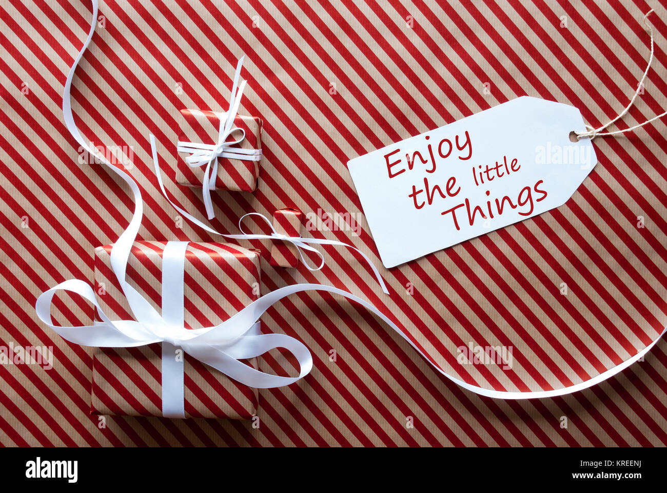 Dos dones o regalos con cinta blanca. Rayas rojo y marrón del papel de  embalaje. O tarjeta de felicitación de Navidad. Etiqueta con Cotización  Inglés disfrutar de las pequeñas cosas Fotografía de