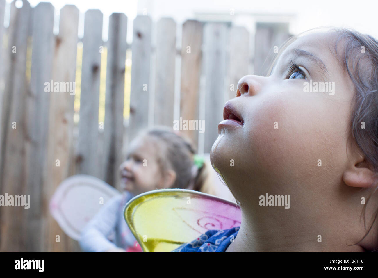 Curioso niñas vistiendo las alas de hadas afuera Foto de stock