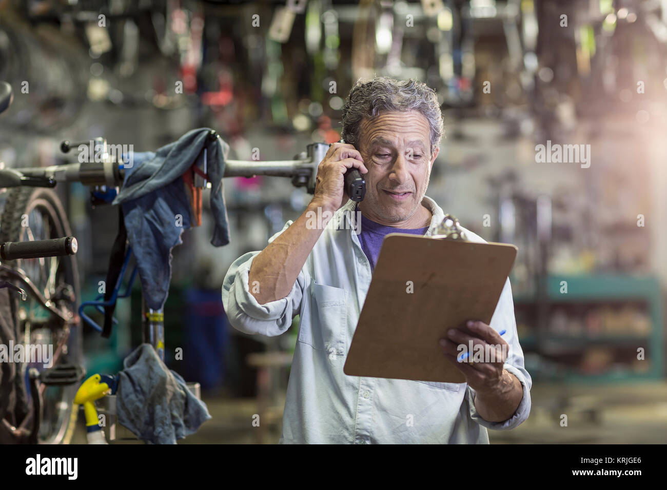Hombre caucásico en la tienda de bicicletas hablando por teléfono Foto de stock