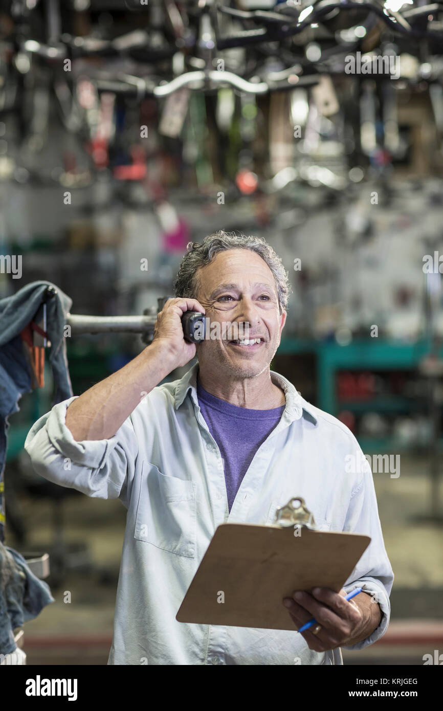 Hombre caucásico en la tienda de bicicletas hablando por teléfono Foto de stock