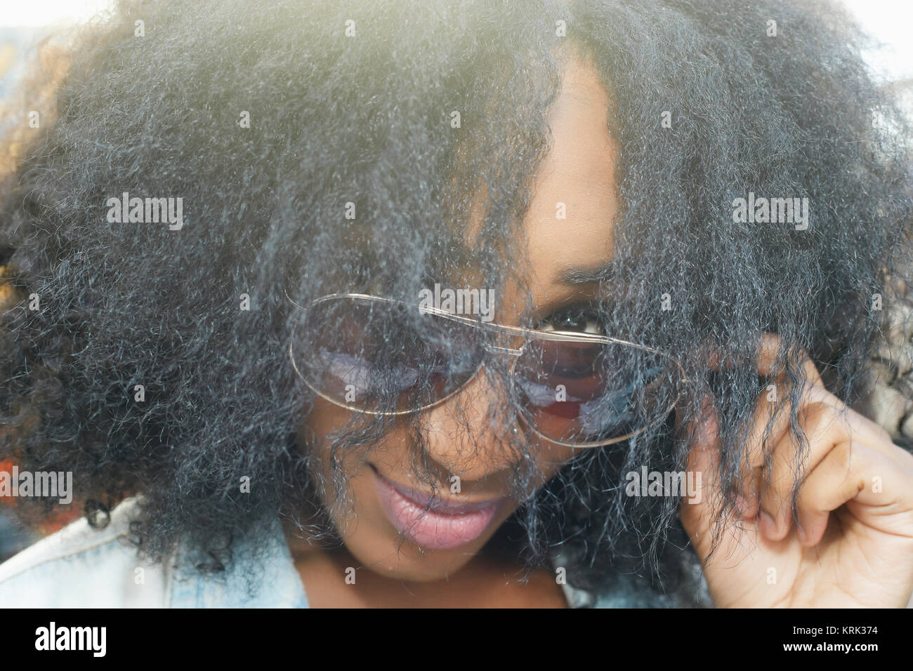 Cerca de raza mixta mujer mirando sobre gafas de sol Foto de stock