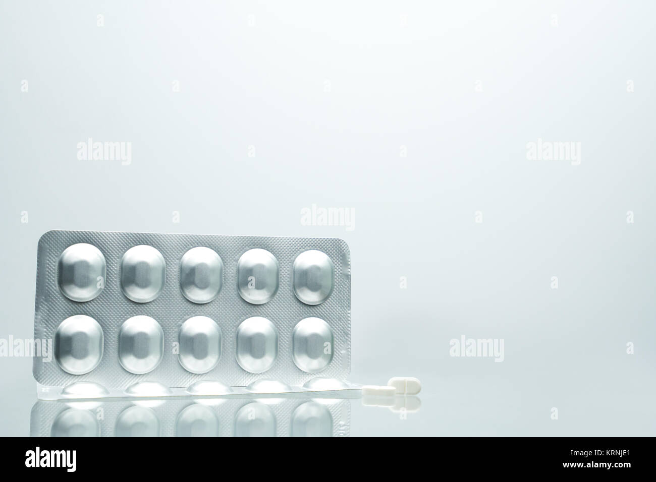 Lámina de aluminio plata blister de pastillas con 2 pastillas tableta  blanca sobre fondo blanco con sombras y copiar el espacio para el texto.  Packagi farmacéutica Fotografía de stock - Alamy