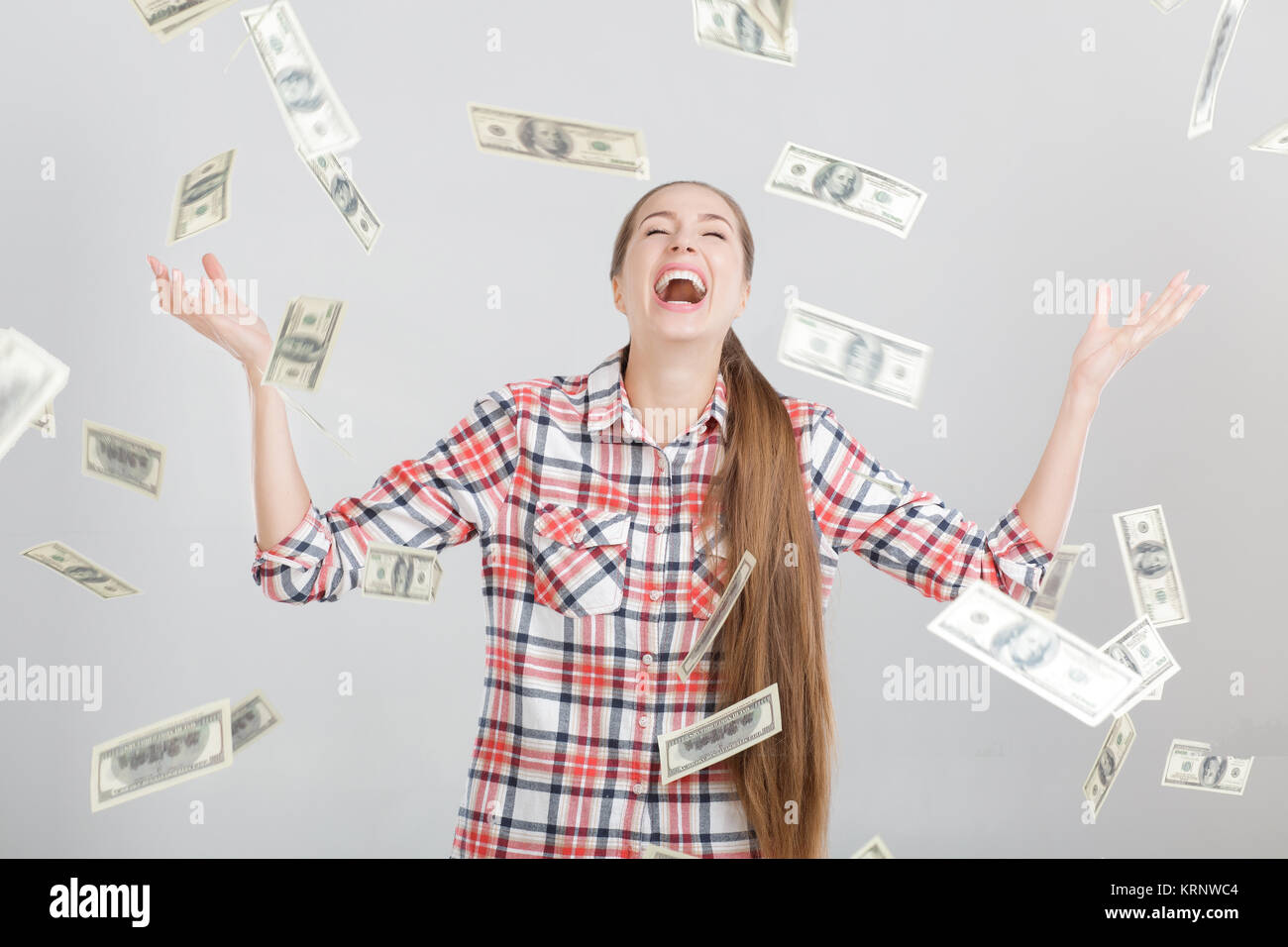 Feliz Mujer de pie bajo la lluvia de dinero Foto de stock
