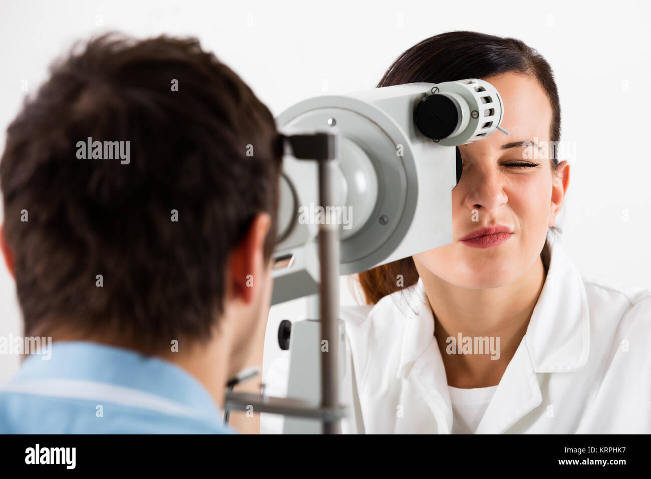 Optometrista haciendo pruebas de visión para el paciente Fotografía de